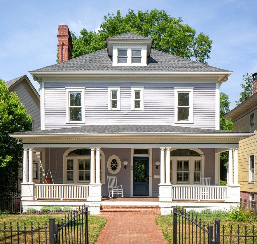 Historic home exterior remodel with gray siding, white window trim, and brick walkway and front porch.