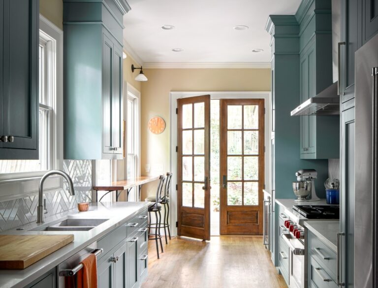 Transitional kitchen with blue cabinets, stainless steel appliances, and natural wood french door.