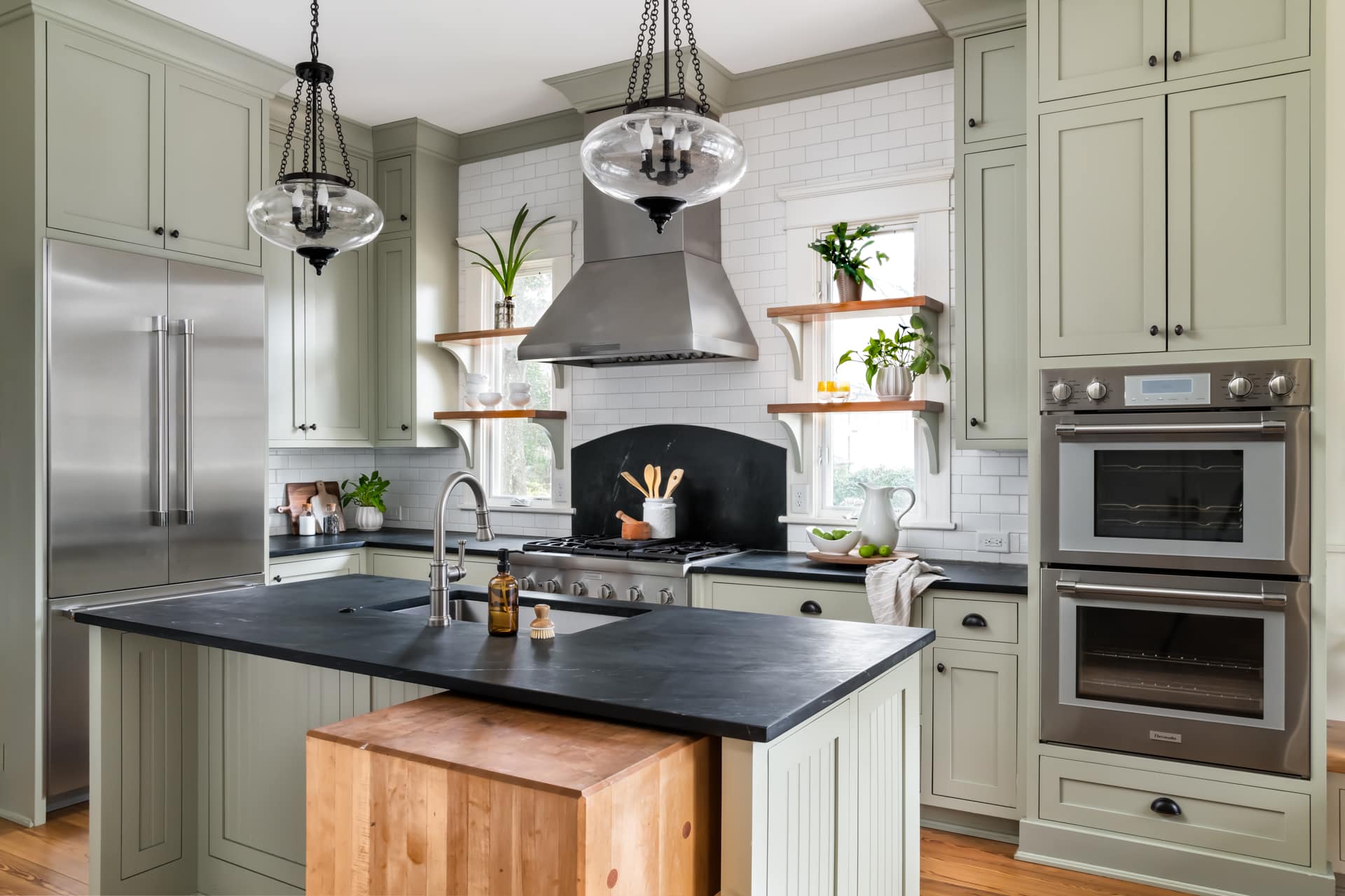 Modern farmhouse kitchen with an island, open shelves, and custom cabinetry.